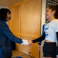 President Mantella shaking hands with student during pancake breakfast.